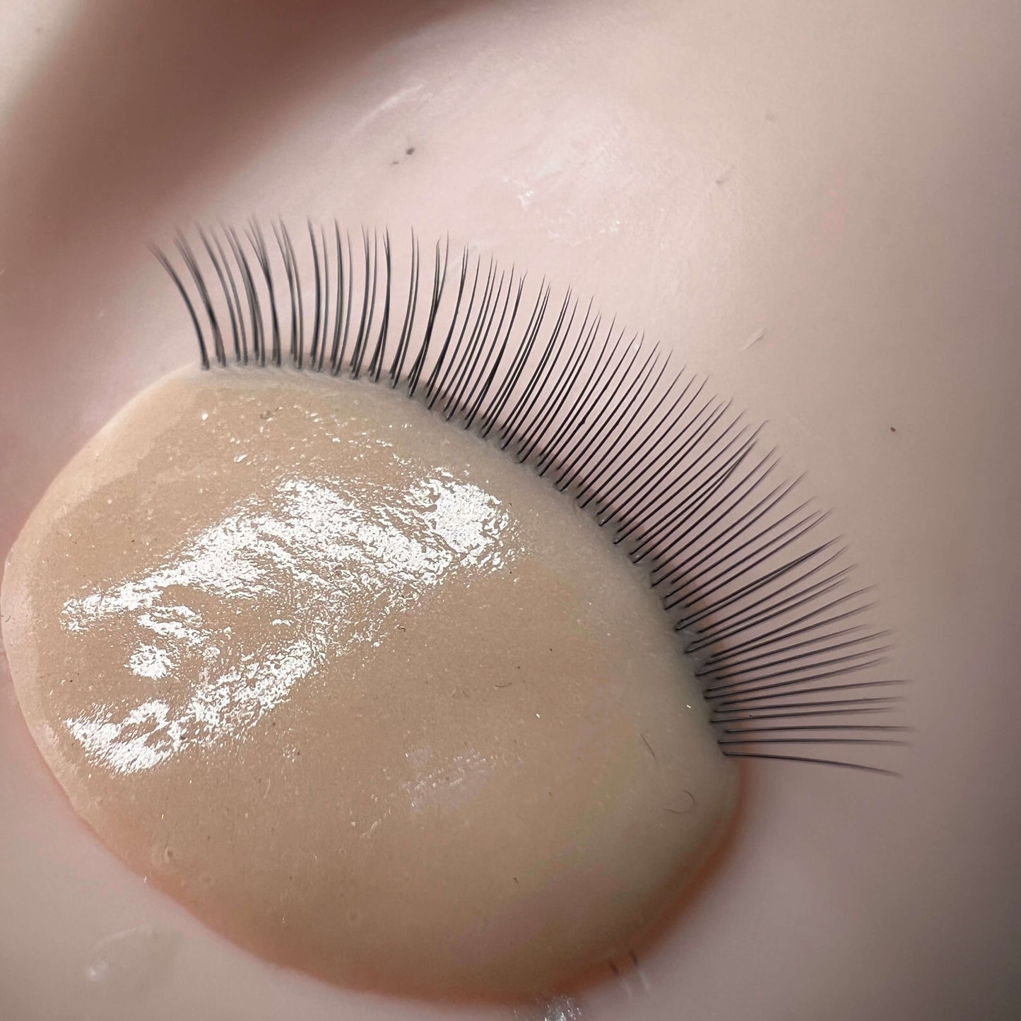 False eyelashes on a beige surface