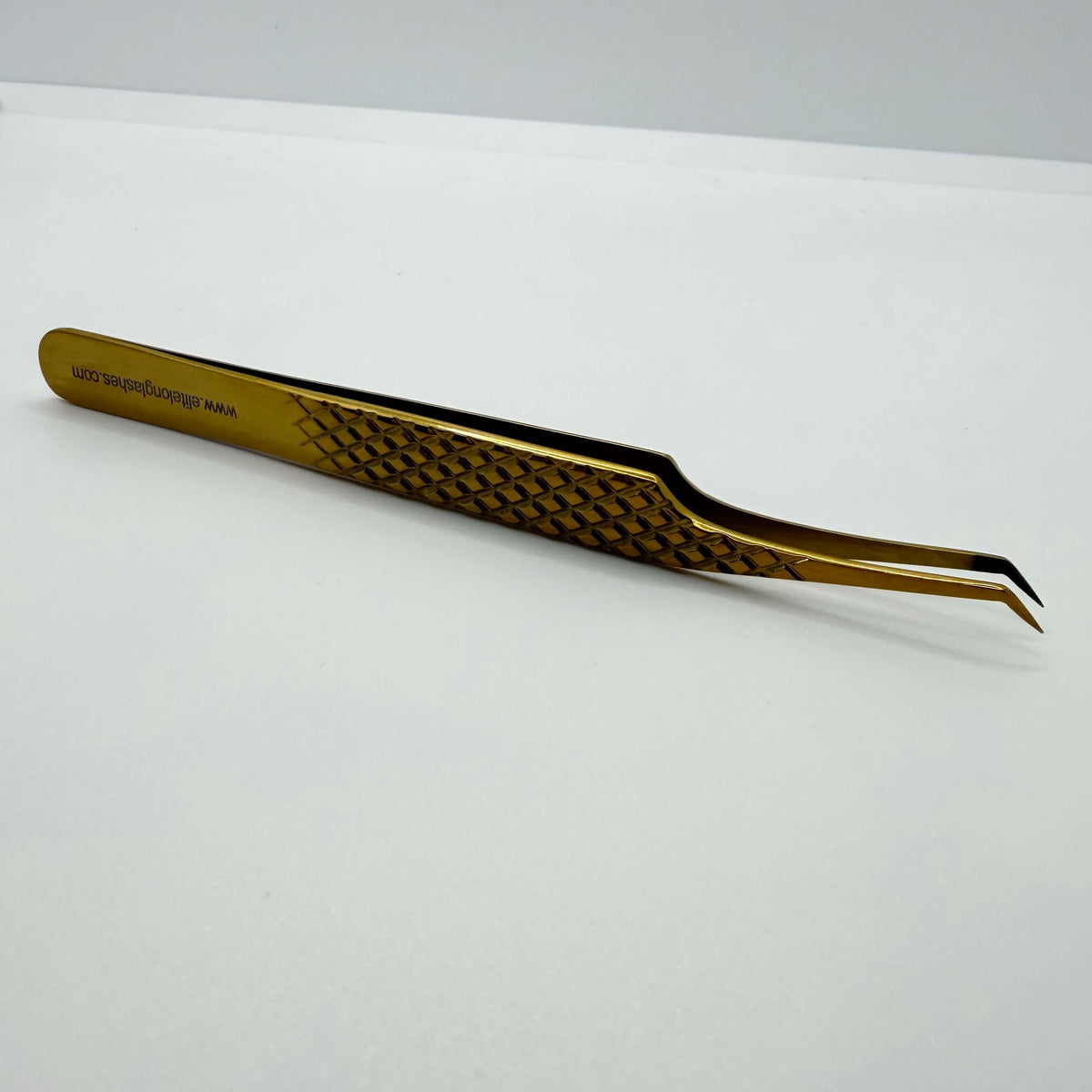 Gold S-shape lash isolation tweezer – textured handle detail