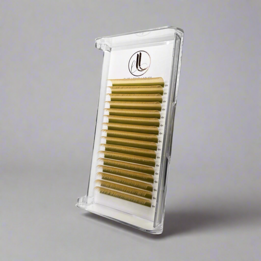 A tray of yellow cashmere false eyelashes arranged in rows, housed in a clear plastic case with a gray background.