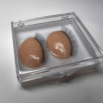 False eyelashes in a clear box on a light gray background