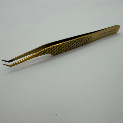Gold-colored tweezers on a white background
