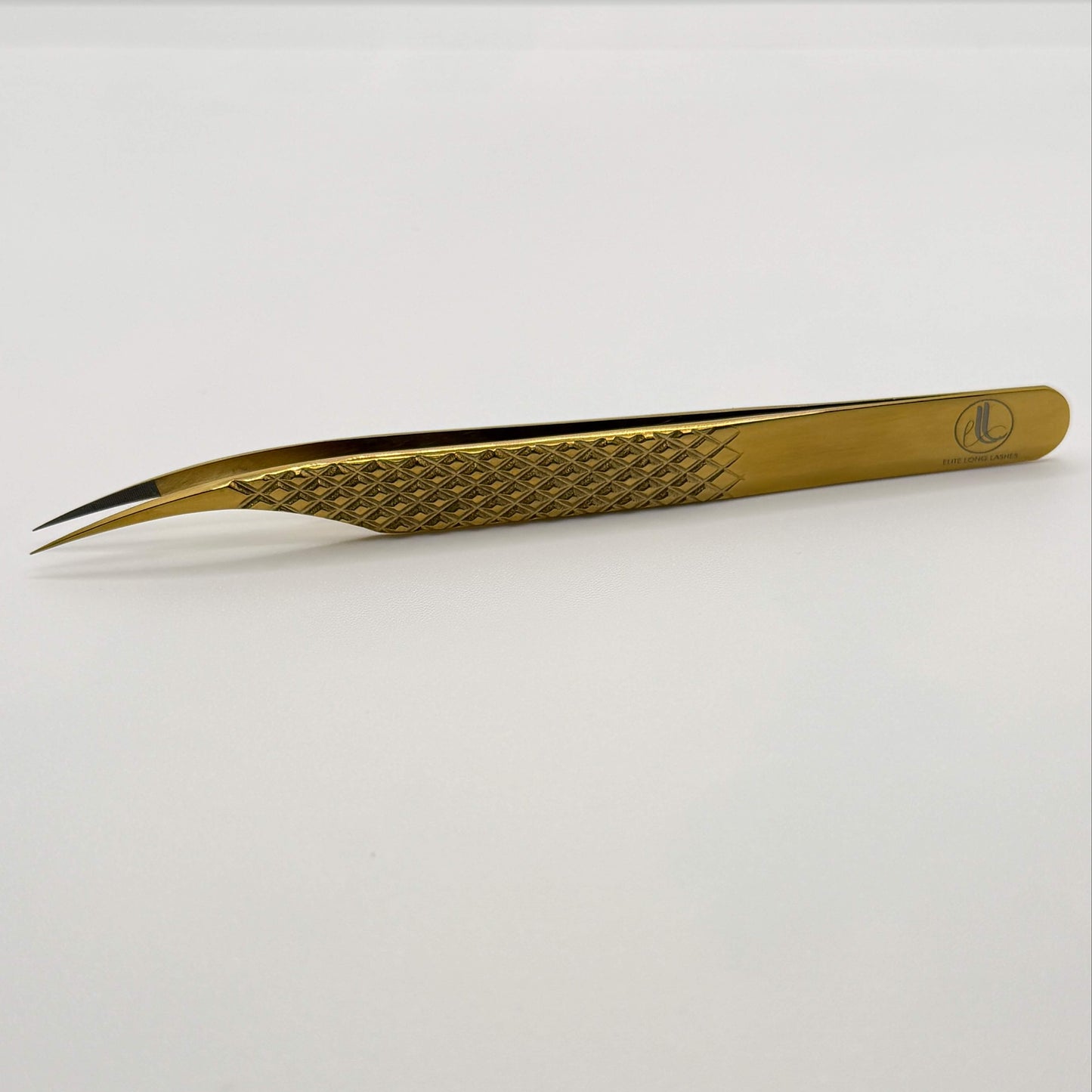 Gold-colored tweezers on a white background