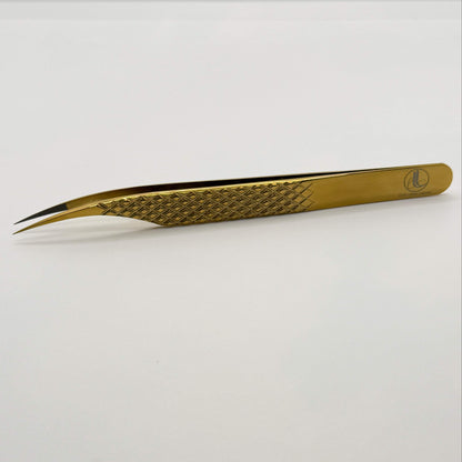 Gold-colored tweezers on a white background