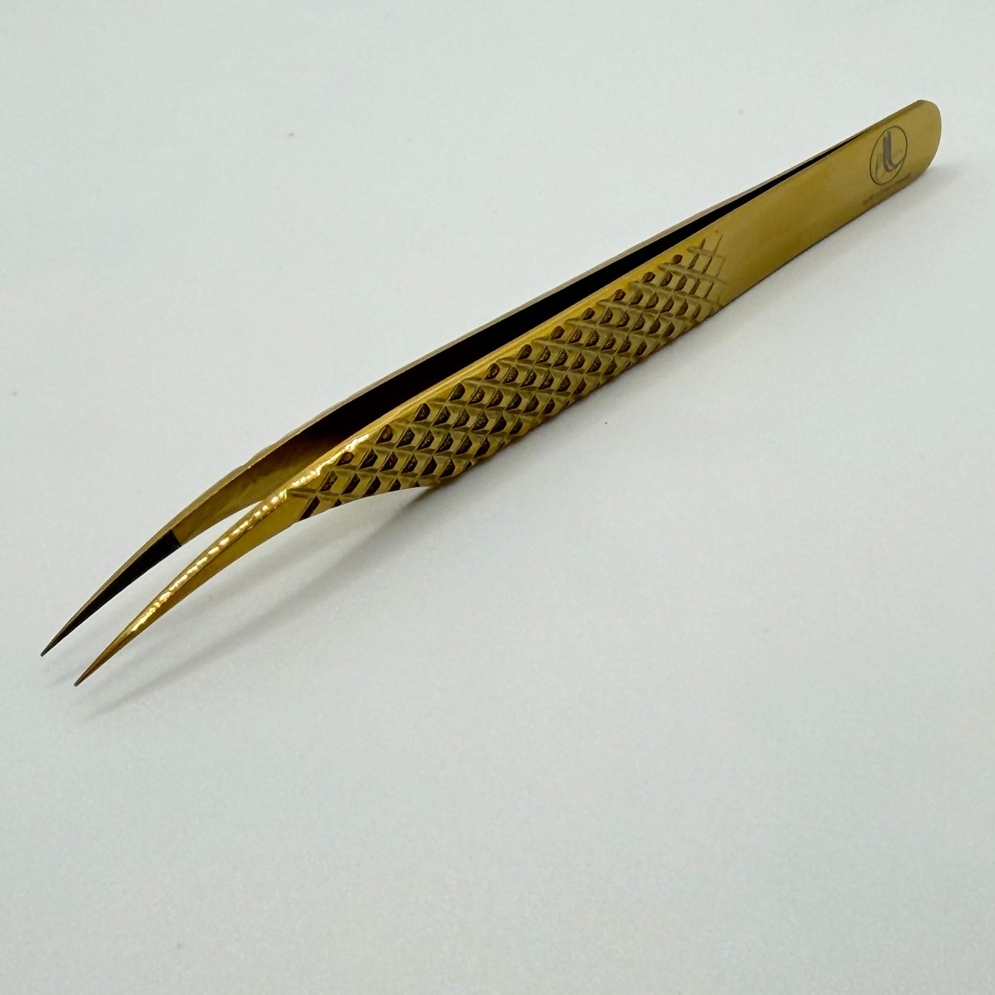 Gold-colored tweezers on a white background