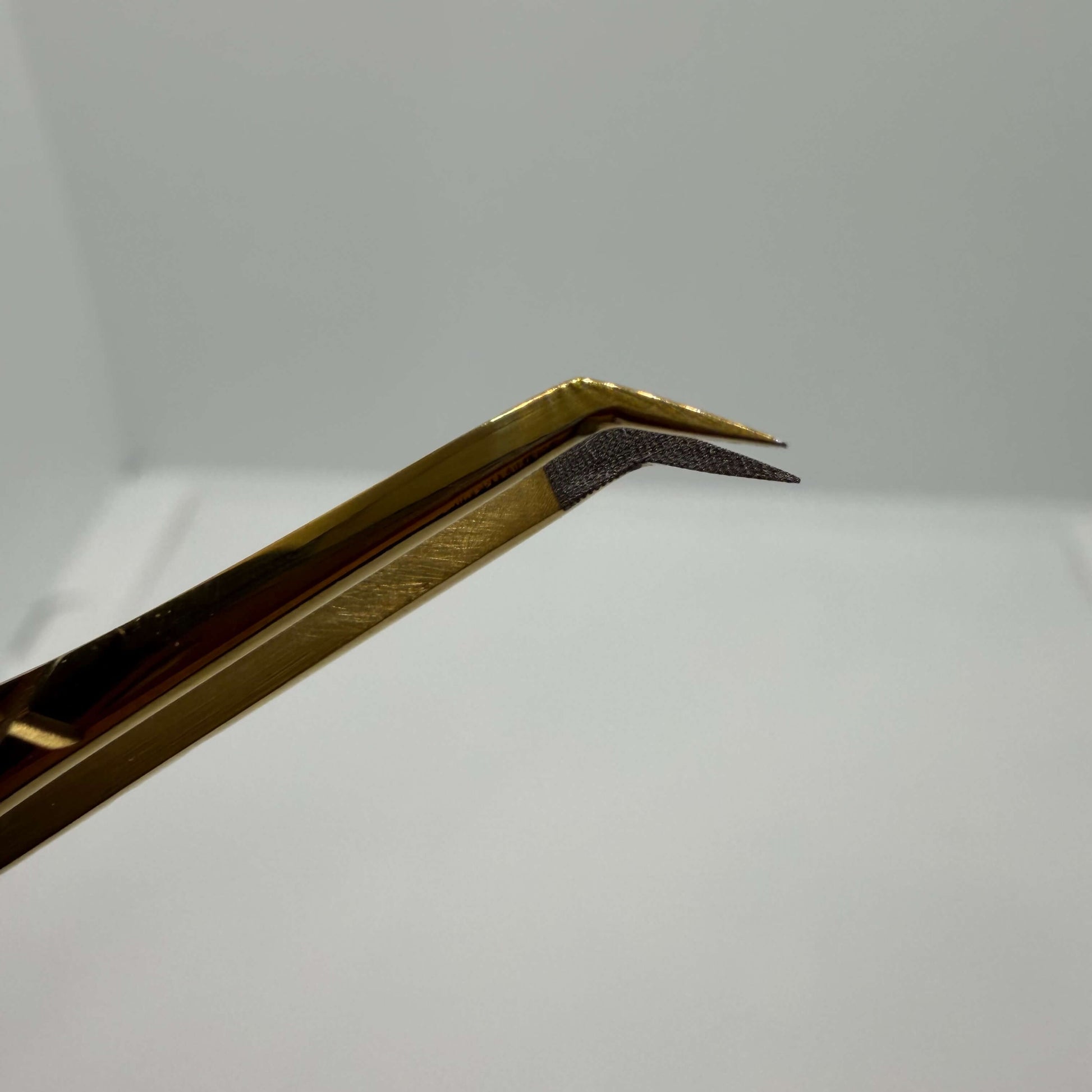 Gold colored tweezers closeup of points