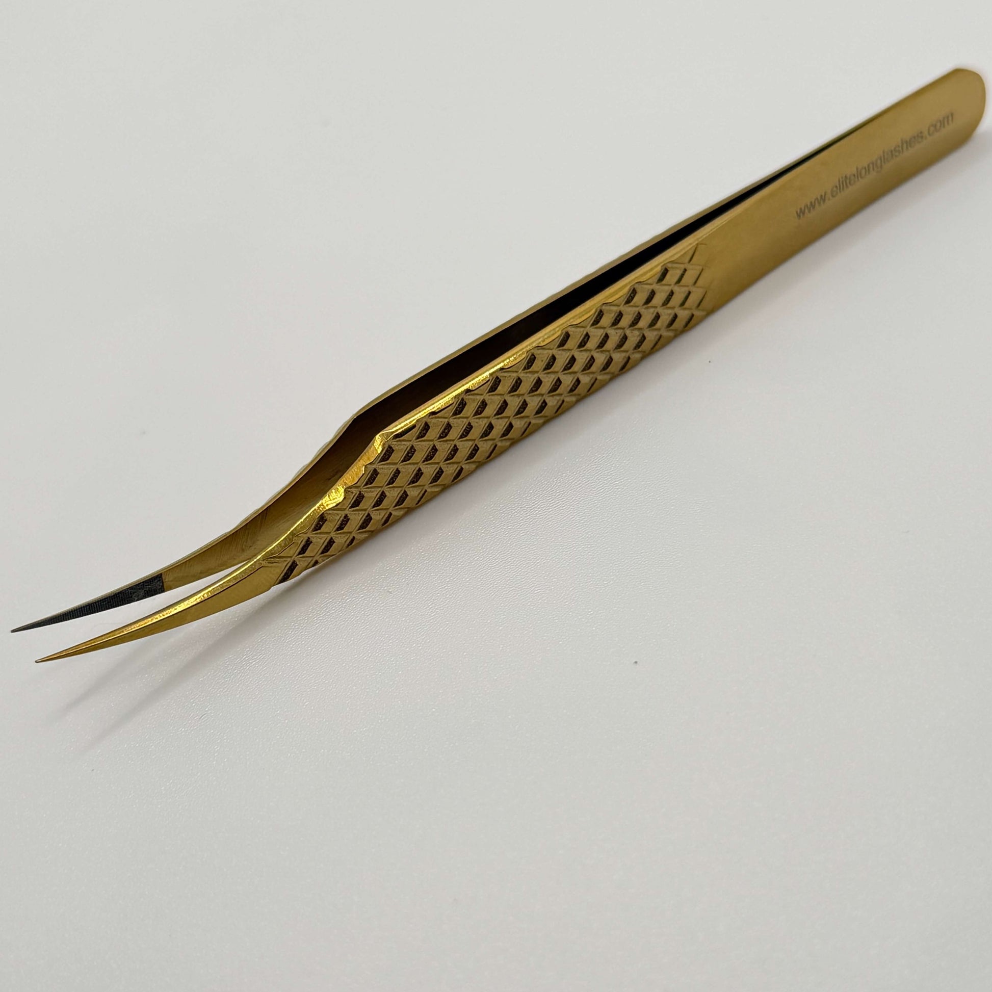 Gold tweezers on a white background