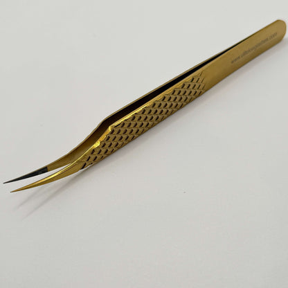 Gold tweezers on a white background