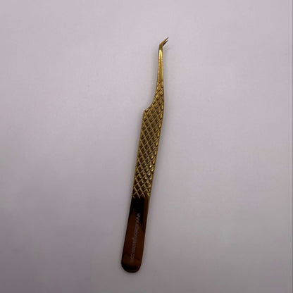 Gold tweezers with a textured handle on a light gray background