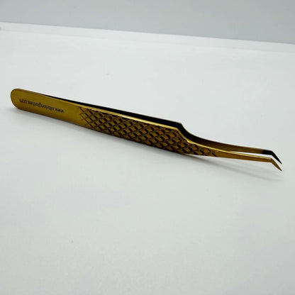 Gold tweezers with a textured handle on a white background