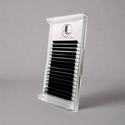 A tray of false eyelashes in a matte black color, displayed in a clear plastic case with a brand logo on the top.