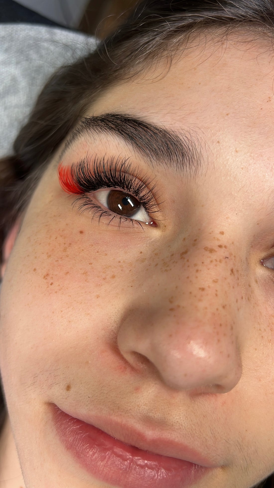 Client wearing black lashes with Candy Red color lash accents