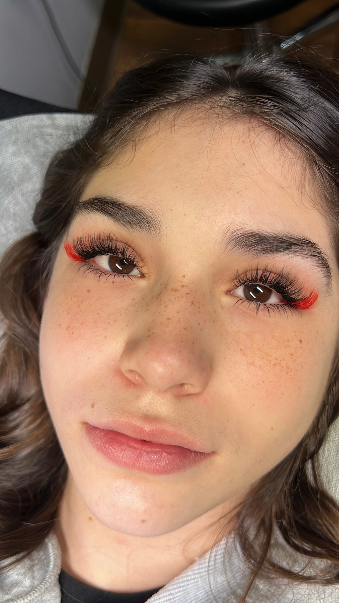 Full-face client wearing black lashes with Candy Red lash accents