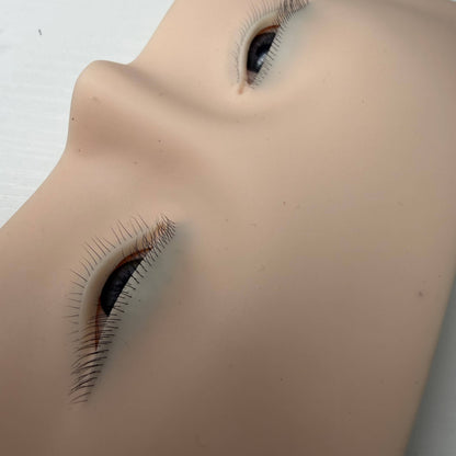 Close-up of realistic 3D eyes on a silicone eyelash extension practice face